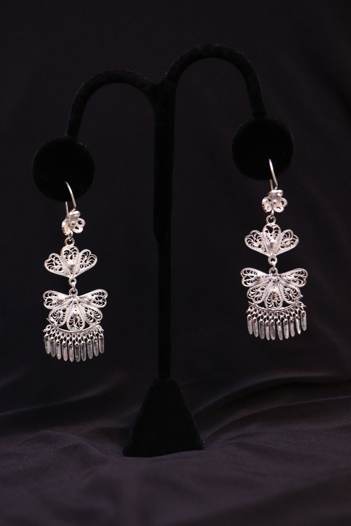Pair of handmade sterling silver chandelier earrings featuring intricate Mexican filigree scrollwork.