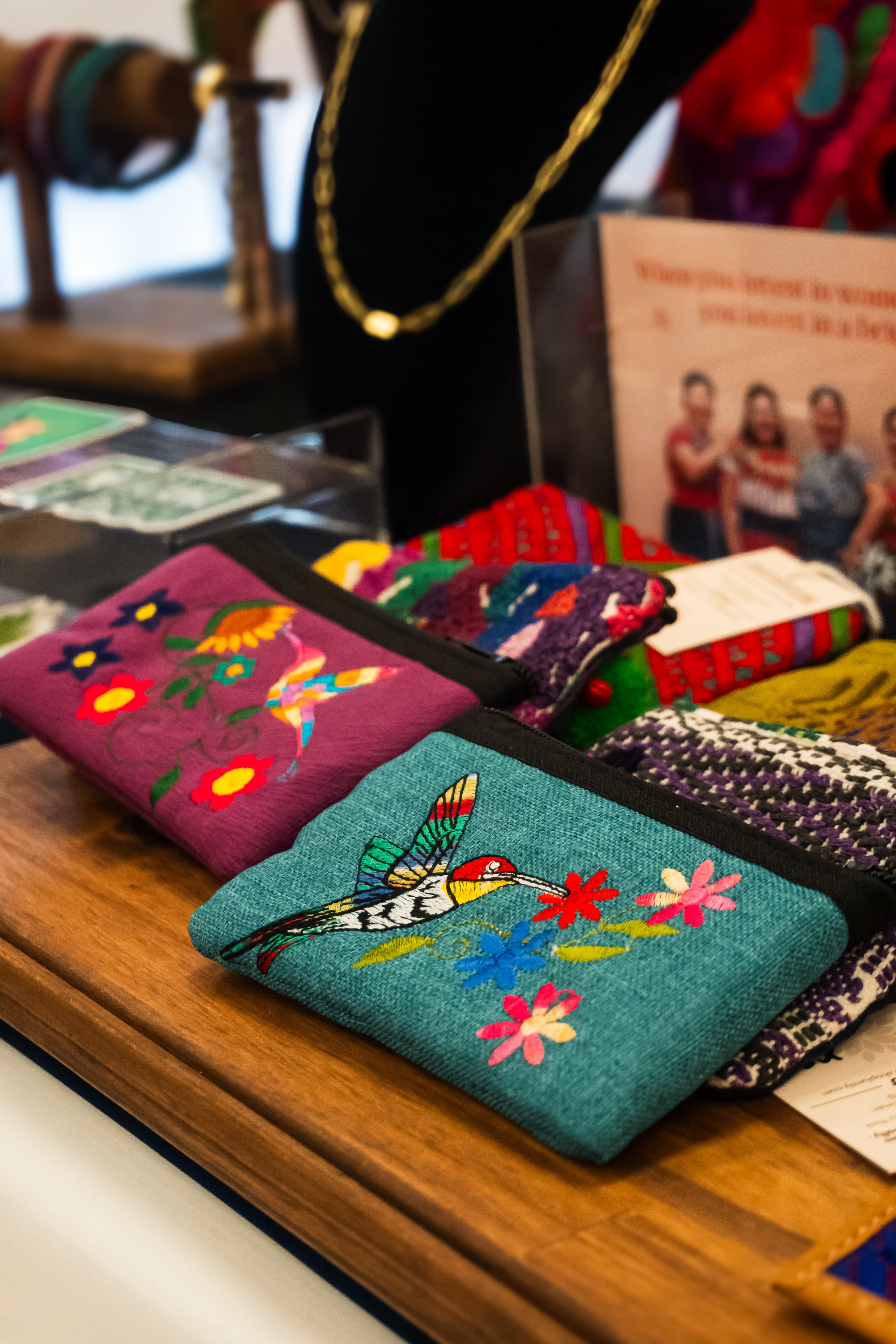 Handmade colorful embroidered coin purse with a colibri and floral design.
