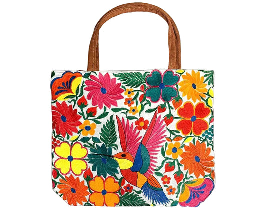 Embroidered hummingbird tote bag featuring colorful floral details and vegan leather accents.