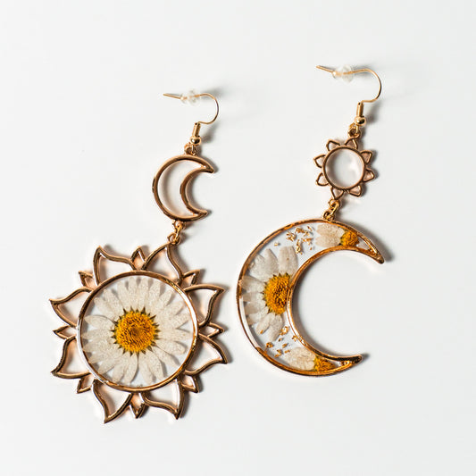 Handcrafted sun and moon-shaped gold earrings with real white pressed daisies.