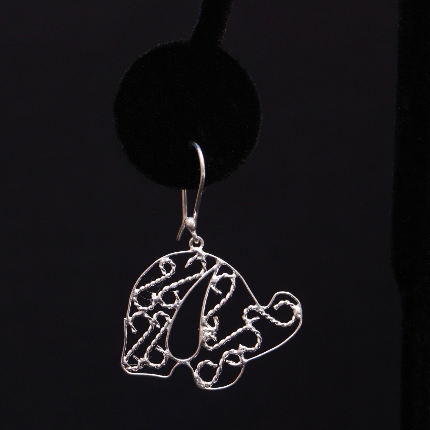 A pair of sterling silver elephant earrings, intricately handmade, displayed against a dark background.